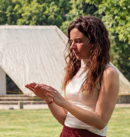 Martina con le mani sollevate durante un trattamento di Pranic Healing all'aperto