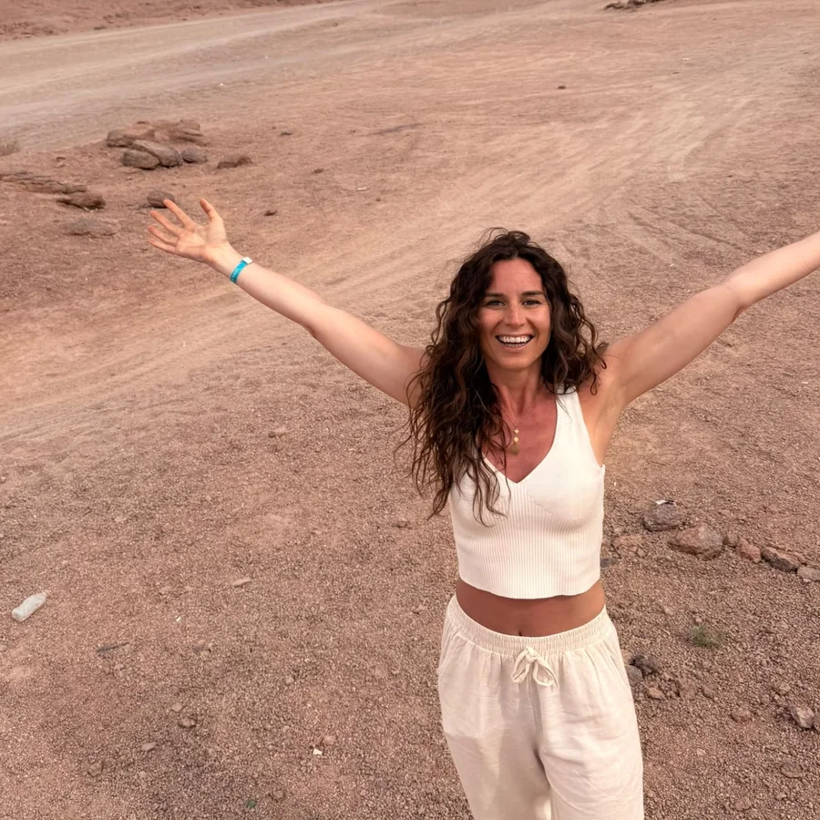 Martina Chiarellotto sorride a braccia aperte nel deserto
