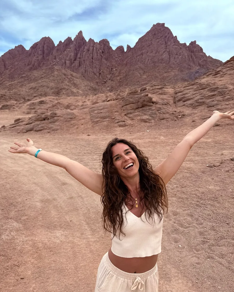 Martina Chiarellotto a braccia aperte nel deserto, davanti alle montagne